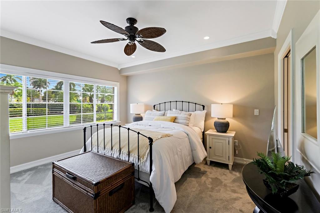 9128 Michael Circle, Unit 9903 Naples, FL 34113 - Photo 17 of 25 a spacious bedroom with a bed and a chandelier