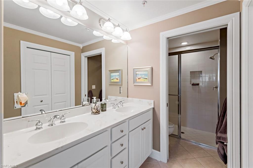 9128 Michael Circle, Unit 9903 Naples, FL 34113 - Photo 18 of 25 a bathroom with a sink double vanity and a mirror