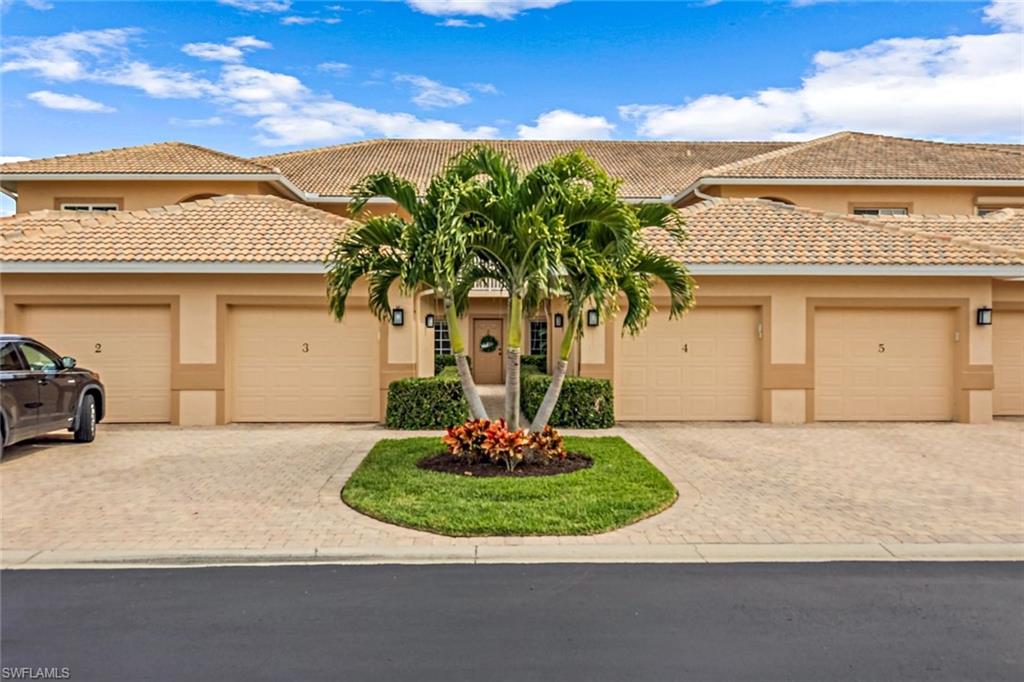 9128 Michael Circle, Unit 9903 Naples, FL 34113 - Photo 2 of 25 a front view of a house with a yard