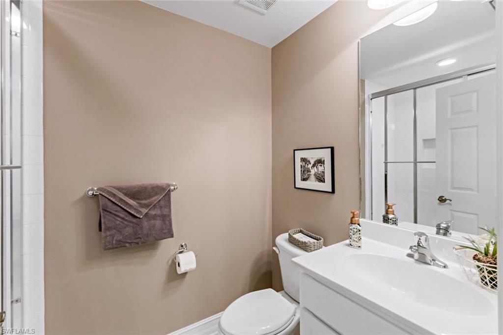 9128 Michael Circle, Unit 9903 Naples, FL 34113 - Photo 21 of 25 a bathroom with a toilet a sink and mirror
