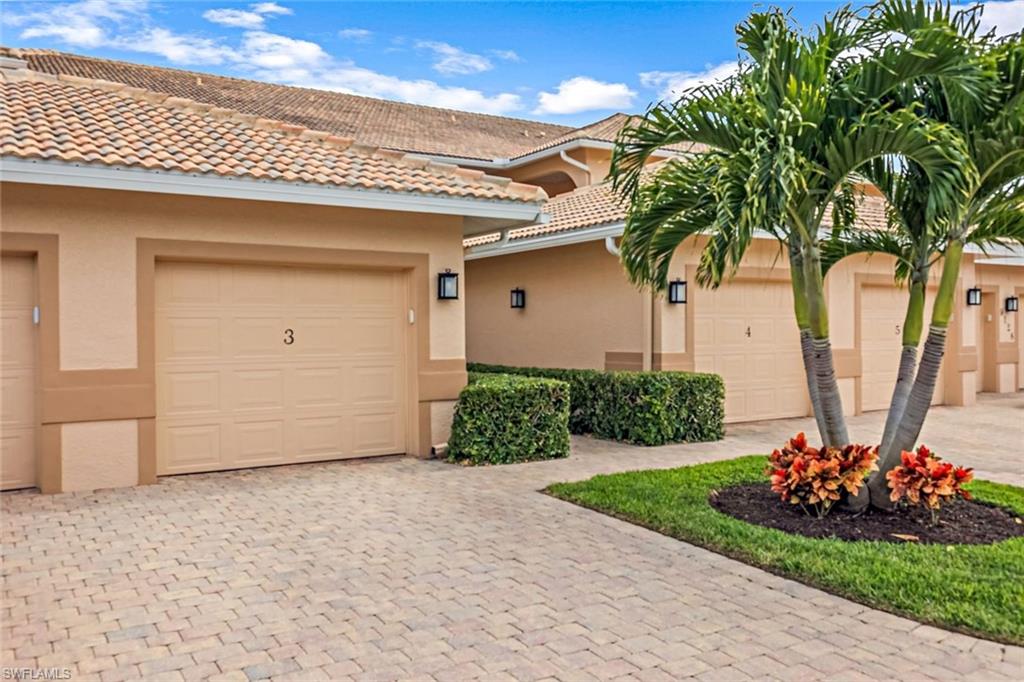 9128 Michael Circle, Unit 9903 Naples, FL 34113 - Photo 22 of 25 a front view of a house with a garden