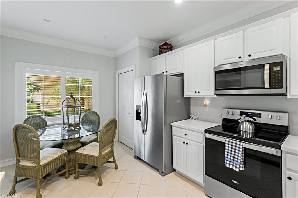 9128 Michael Circle, Unit 9903 Naples, FL 34113 - Photo 6 of 25 a kitchen with stainless steel appliances a refrigerator stove and white cabinets