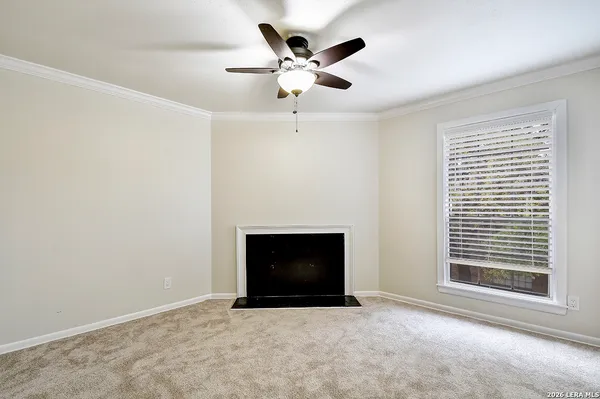 an empty room with ceiling fan and window