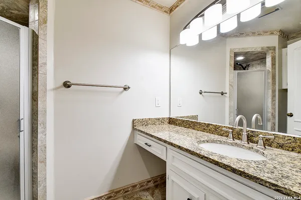 a bathroom with a granite countertop sink and a mirror