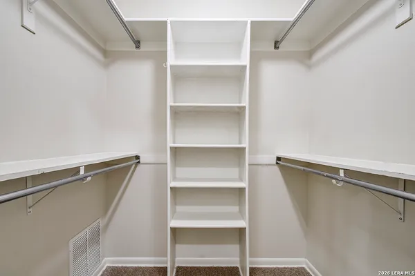 a view of walk in closet with empty racks