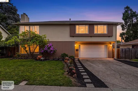 a front view of house and yard with beautiful flowers and green space