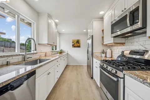 a kitchen with stainless steel appliances a sink a stove and cabinets
