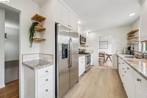 a kitchen with white cabinets and stainless steel appliances