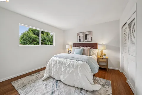 a bedroom with a bed and a wooden floor