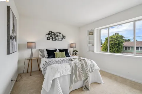 a bed sitting in a bedroom next to a window