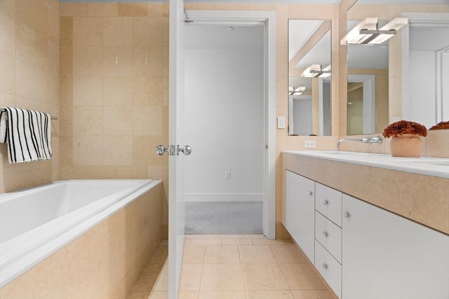 a bathroom with a tub sink and mirror