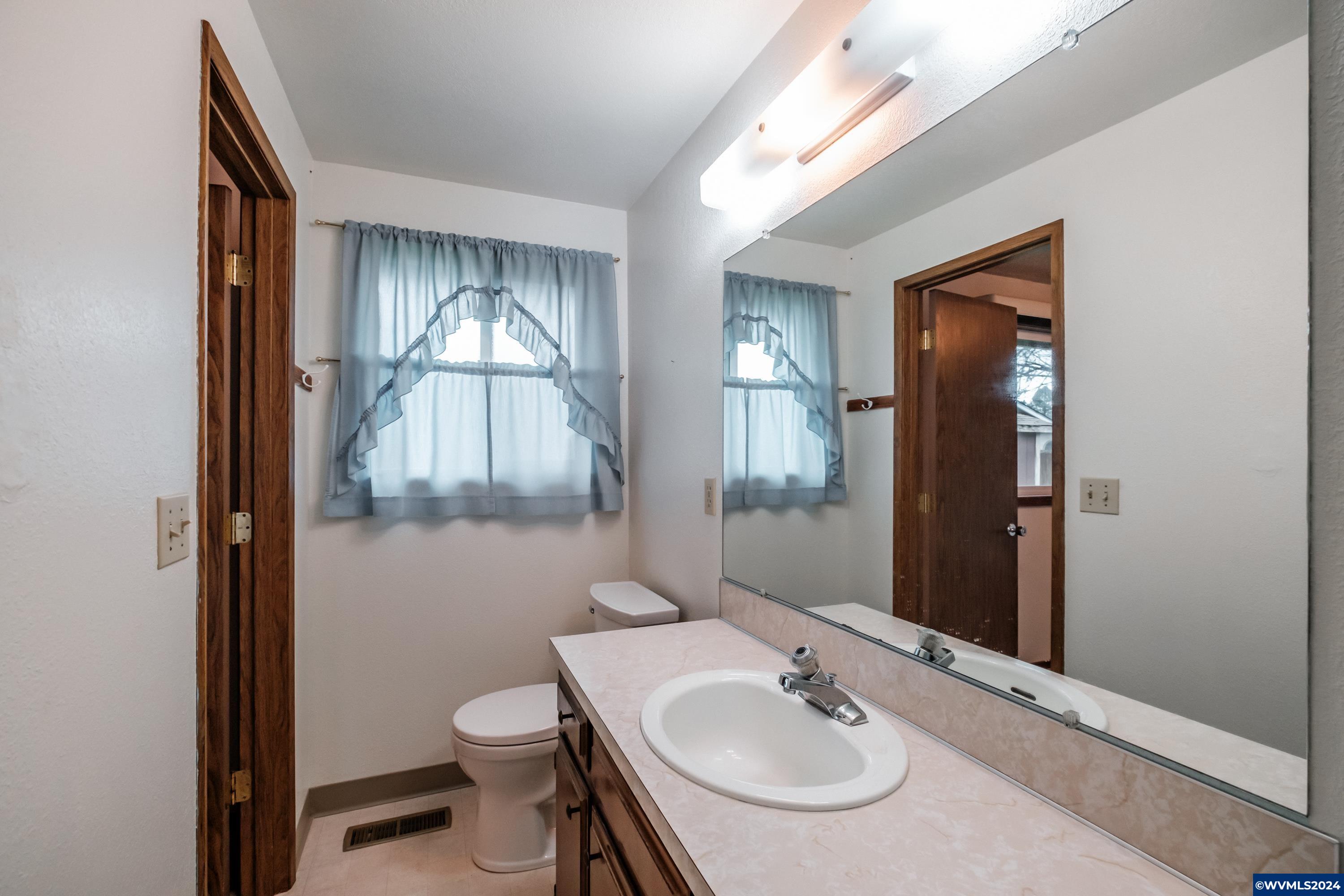 4775 Swegle Road Northeast Salem, OR 97305 - Photo 20 of 38 a bathroom with a toilet a sink and mirror