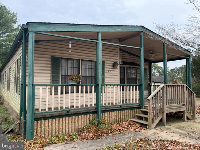 a view of a house with a small yard and wooden fence