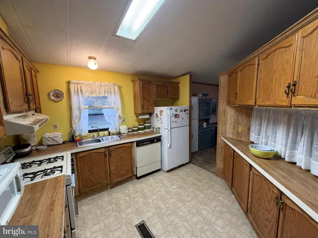 a kitchen with stainless steel appliances granite countertop a stove a sink dishwasher and a refrigerator