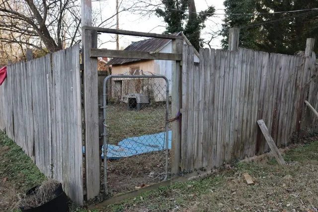 a view of a house with a small yard and wooden fence