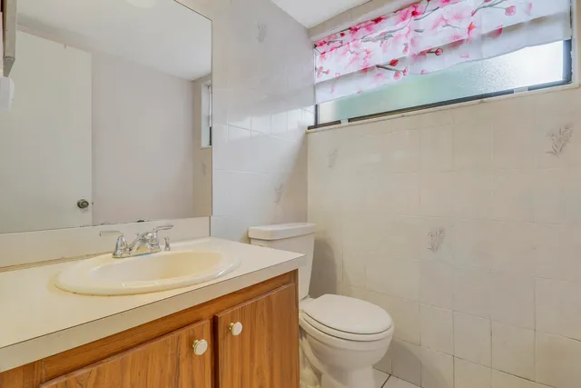 a bathroom with a sink toilet and a mirror