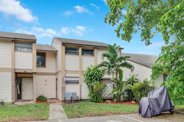 a front view of a house with a garden and plants