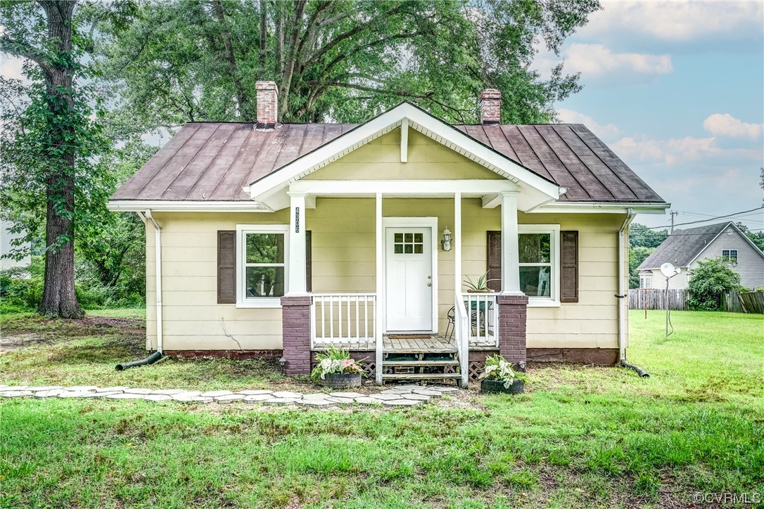 a view of a house with a yard and sitting area