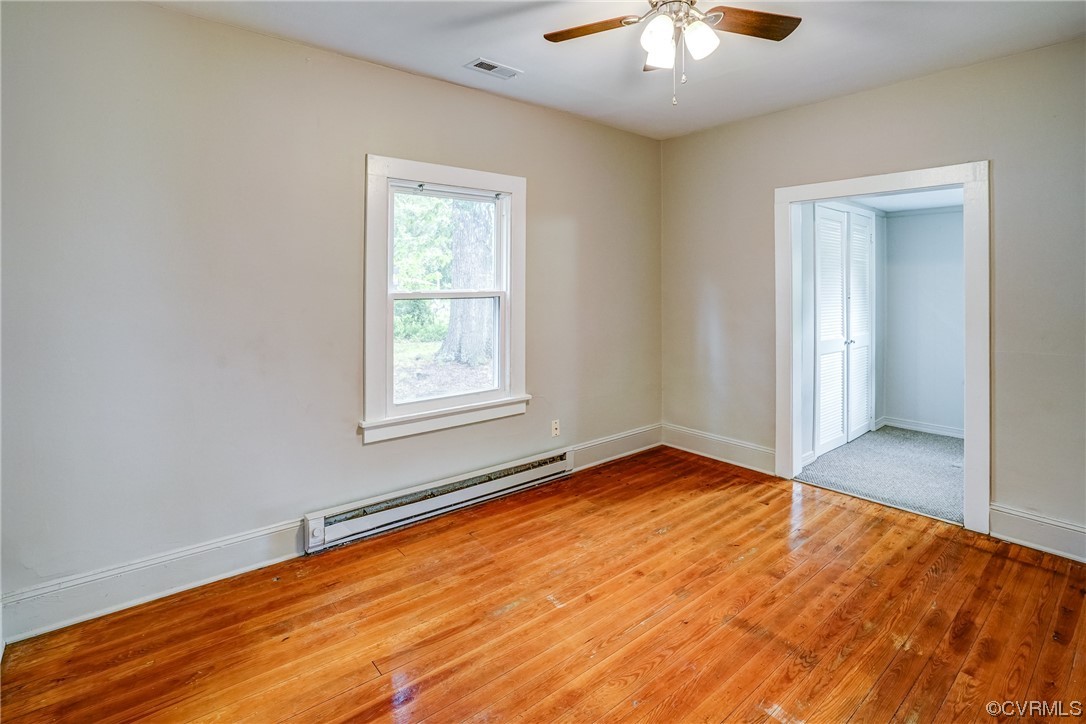 4306 Britannia Road Richmond, VA 23234 - Photo 13 of 20 an empty room with wooden floor chandelier fan and windows