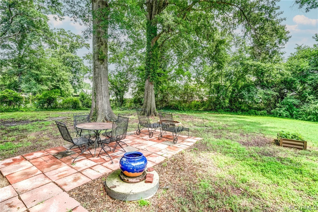 4306 Britannia Road Richmond, VA 23234 - Photo 17 of 20 a view of a patio with table and chairs potted plants and large tree