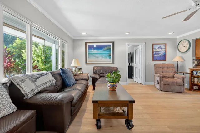 a living room with furniture a chandelier and a dining table with wooden floor