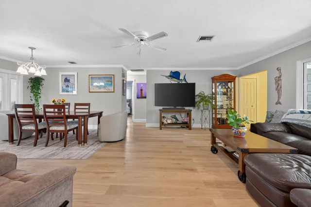 a dining room filled chandelier and wooden floor