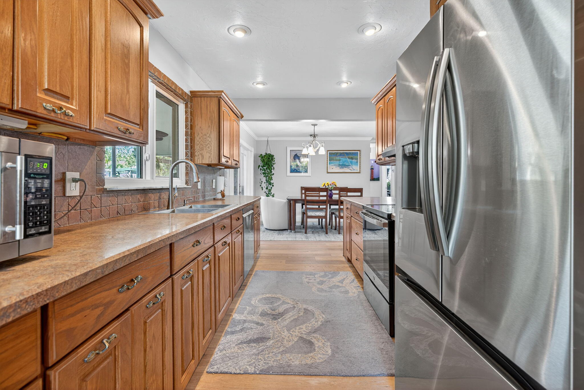 5095 Southeast Manatee Terrace Stuart, FL 34997 - Photo 19 of 58 a kitchen with stainless steel appliances granite countertop refrigerator a sink and dishwasher