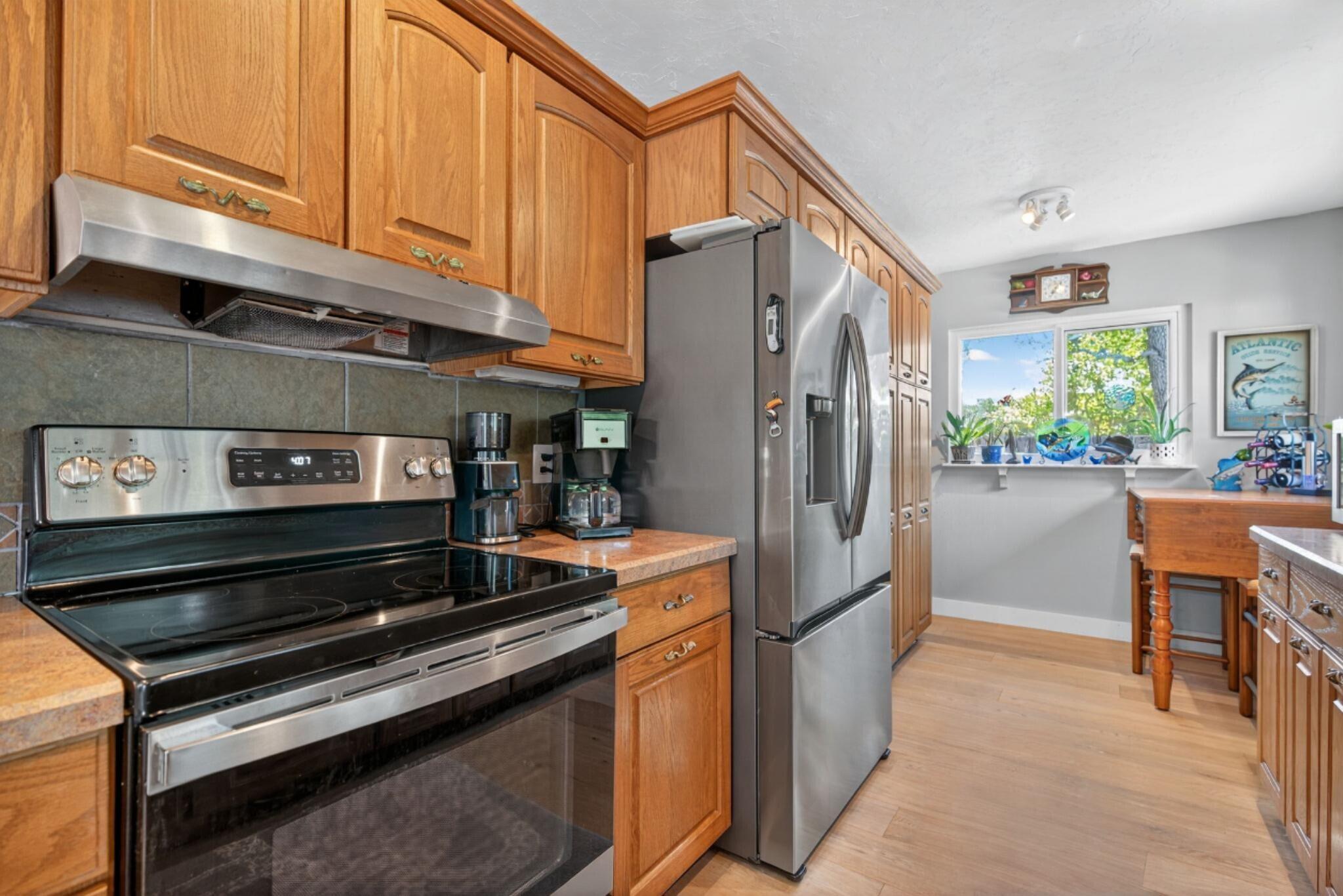 5095 Southeast Manatee Terrace Stuart, FL 34997 - Photo 20 of 58 a kitchen with stainless steel appliances granite countertop a refrigerator and a stove top oven