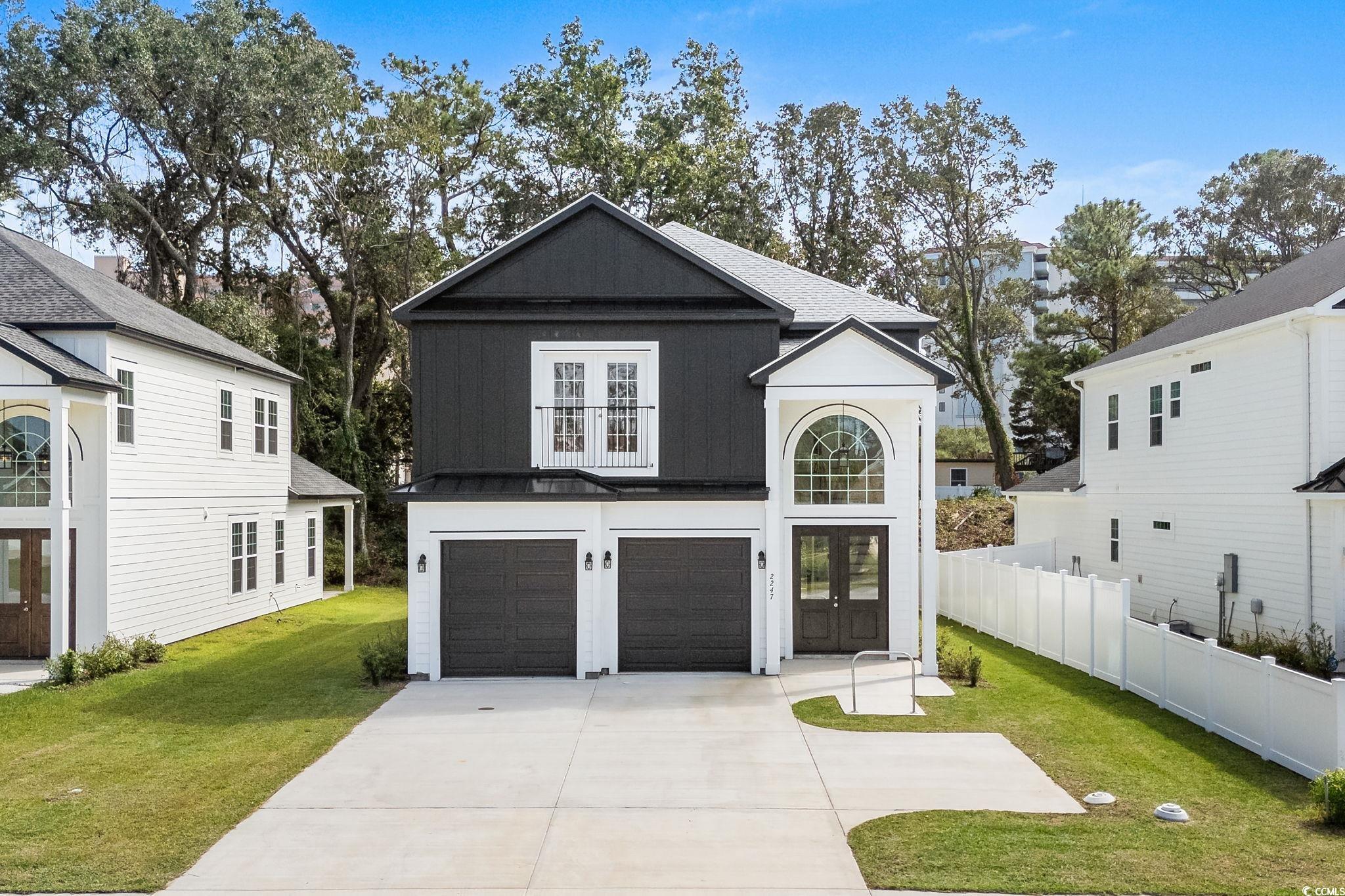 View of front of house featuring a garage, french doors, driveway, and a metal roof