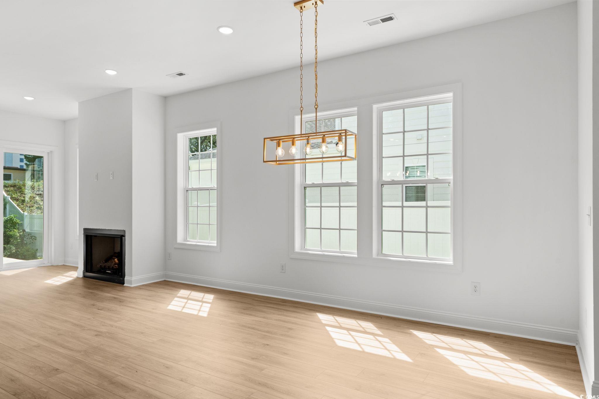 2247 Sand Dunes Drive Myrtle Beach, SC 29577 - Photo 13 of 40 Unfurnished dining area with light wood-style flooring, recessed lighting, a chandelier, and a fireplace