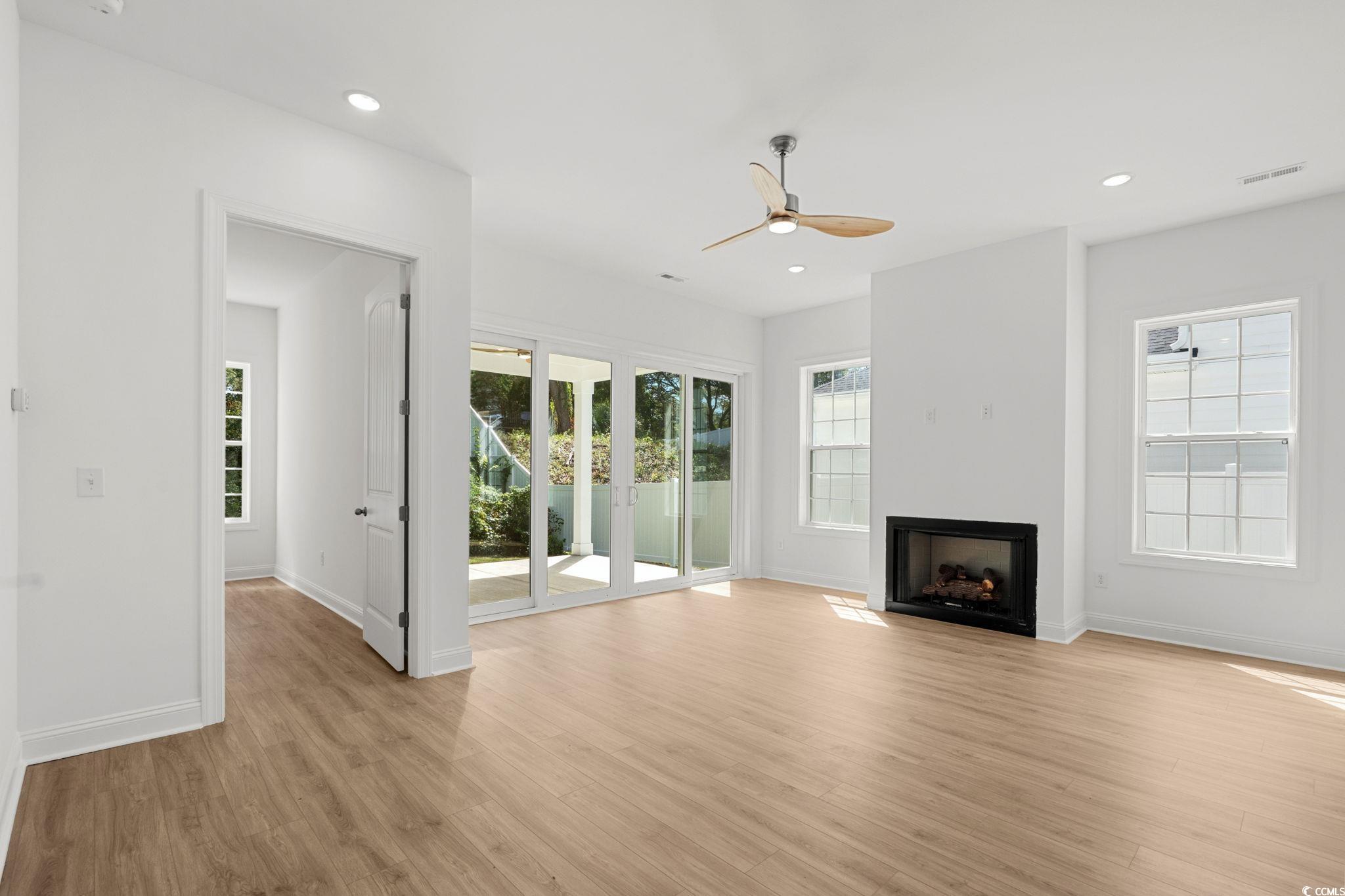 2247 Sand Dunes Drive Myrtle Beach, SC 29577 - Photo 14 of 40 Unfurnished living room with light wood finished floors, recessed lighting, a fireplace, and a ceiling fan