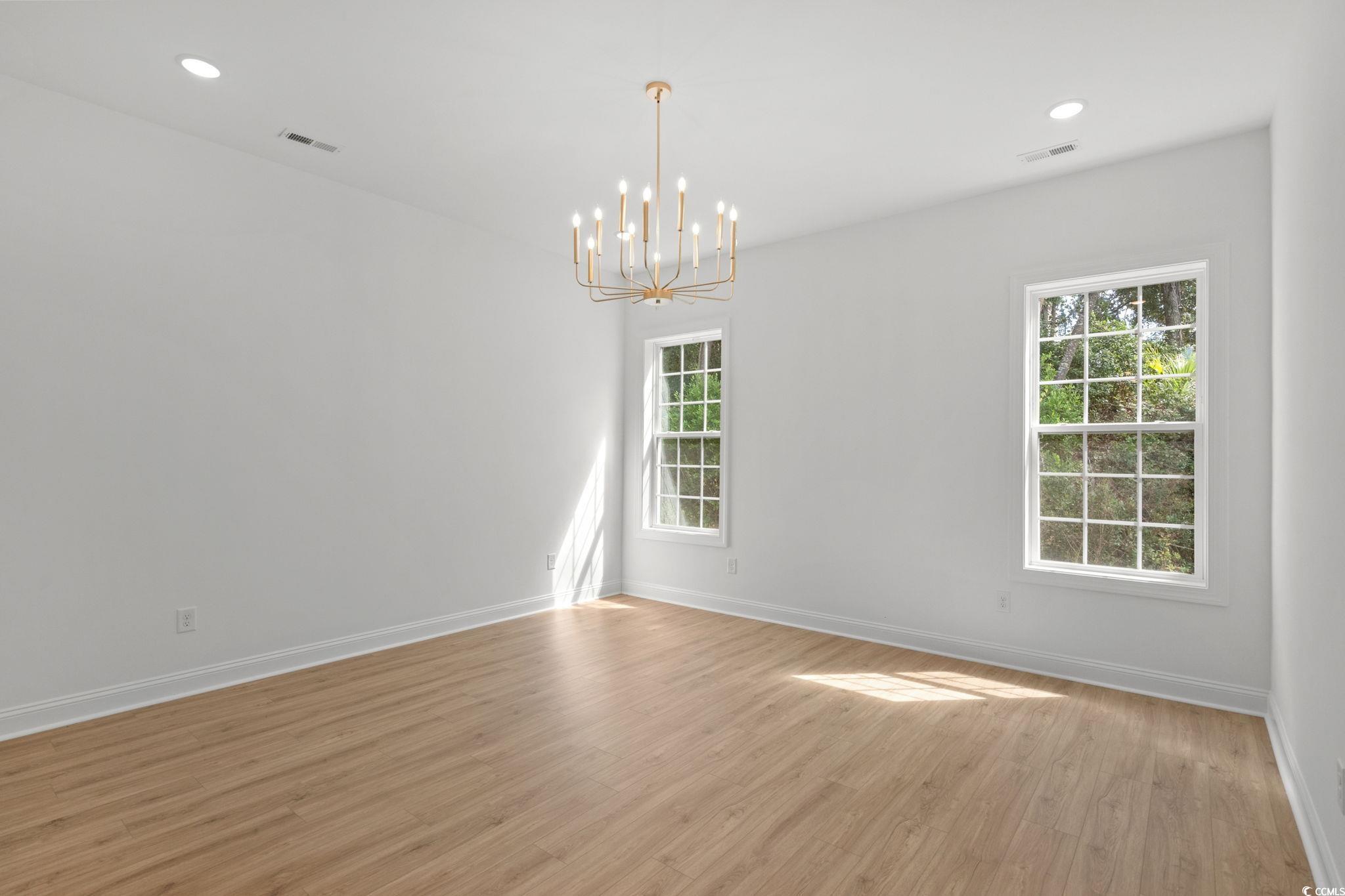 2247 Sand Dunes Drive Myrtle Beach, SC 29577 - Photo 18 of 40 Empty room featuring recessed lighting, light wood-style flooring, and a chandelier