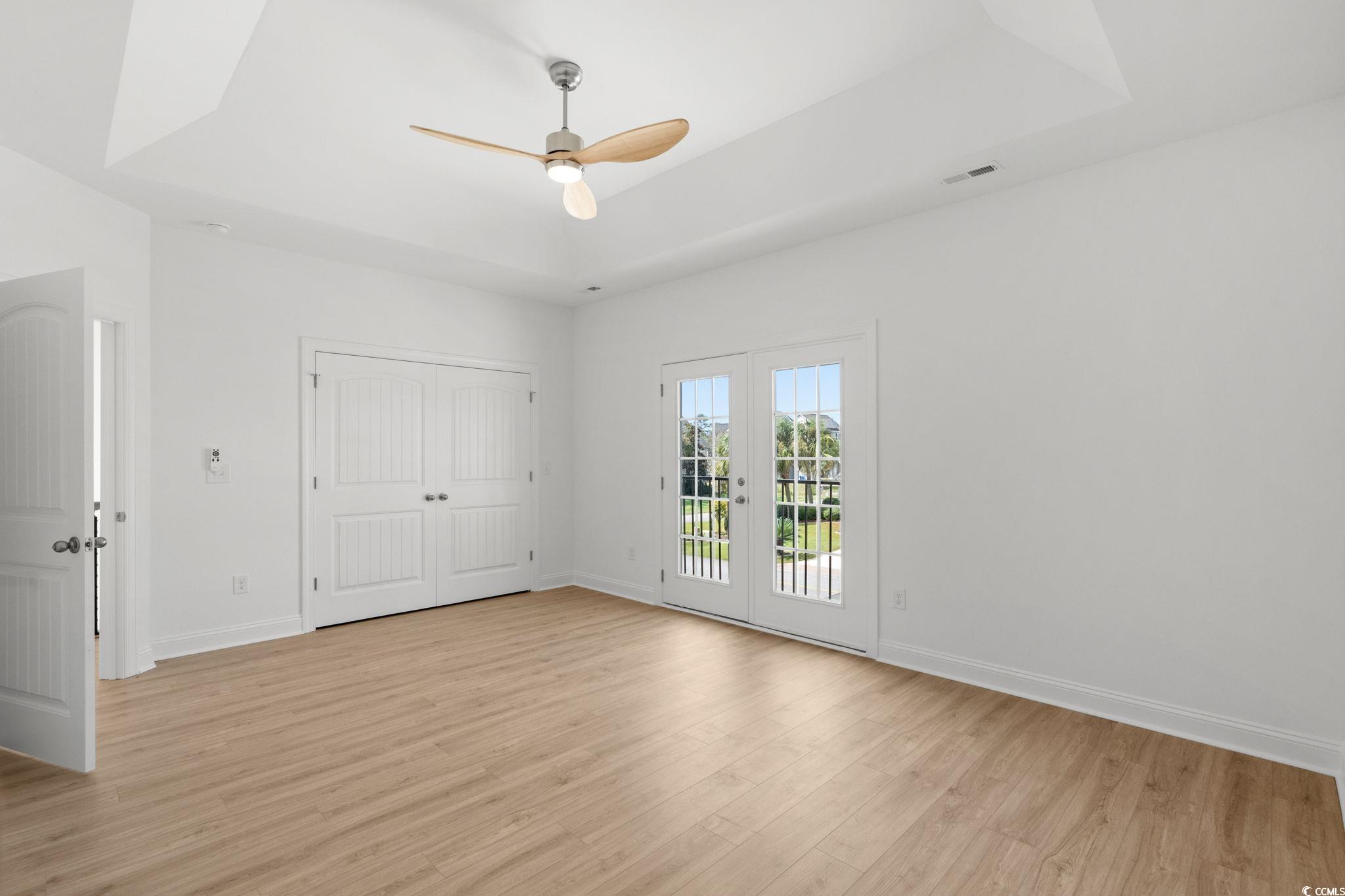 2247 Sand Dunes Drive Myrtle Beach, SC 29577 - Photo 21 of 40 Unfurnished bedroom featuring a tray ceiling, access to exterior, light wood finished floors, and a closet