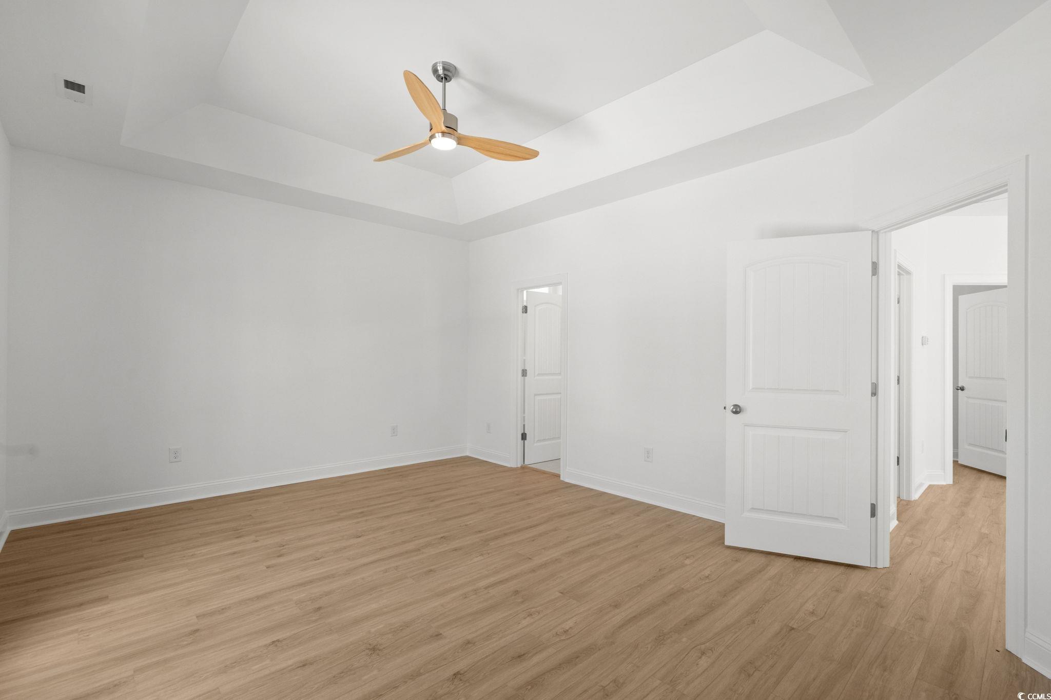 2247 Sand Dunes Drive Myrtle Beach, SC 29577 - Photo 24 of 40 Unfurnished bedroom featuring a raised ceiling, light wood-type flooring, and a ceiling fan
