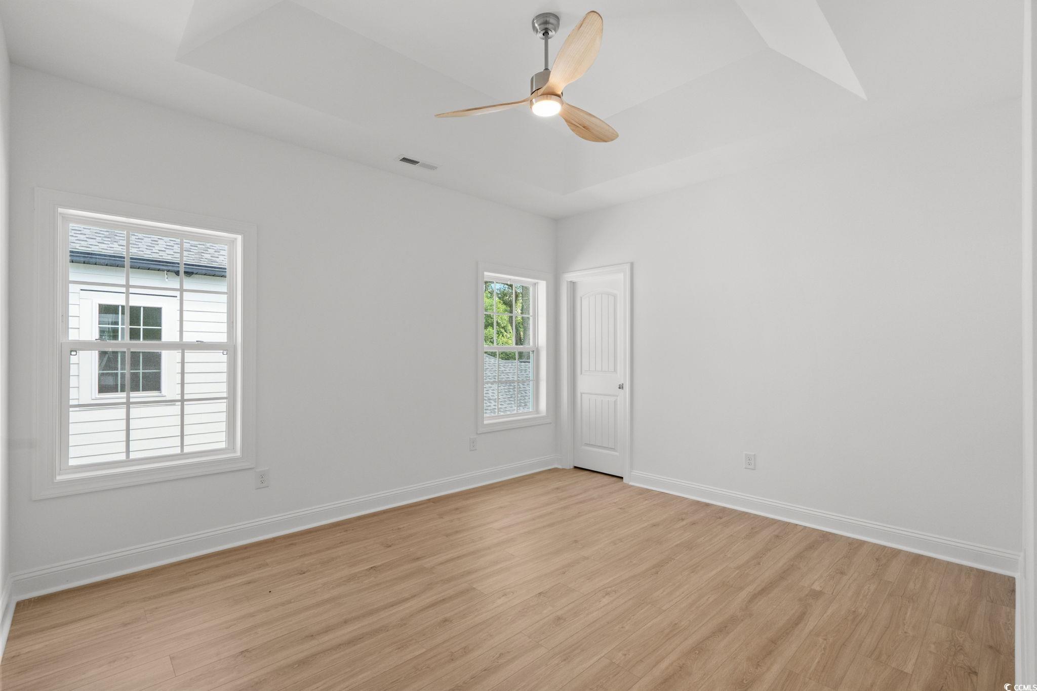 2247 Sand Dunes Drive Myrtle Beach, SC 29577 - Photo 26 of 40 Spare room with light wood-type flooring, a tray ceiling, and ceiling fan