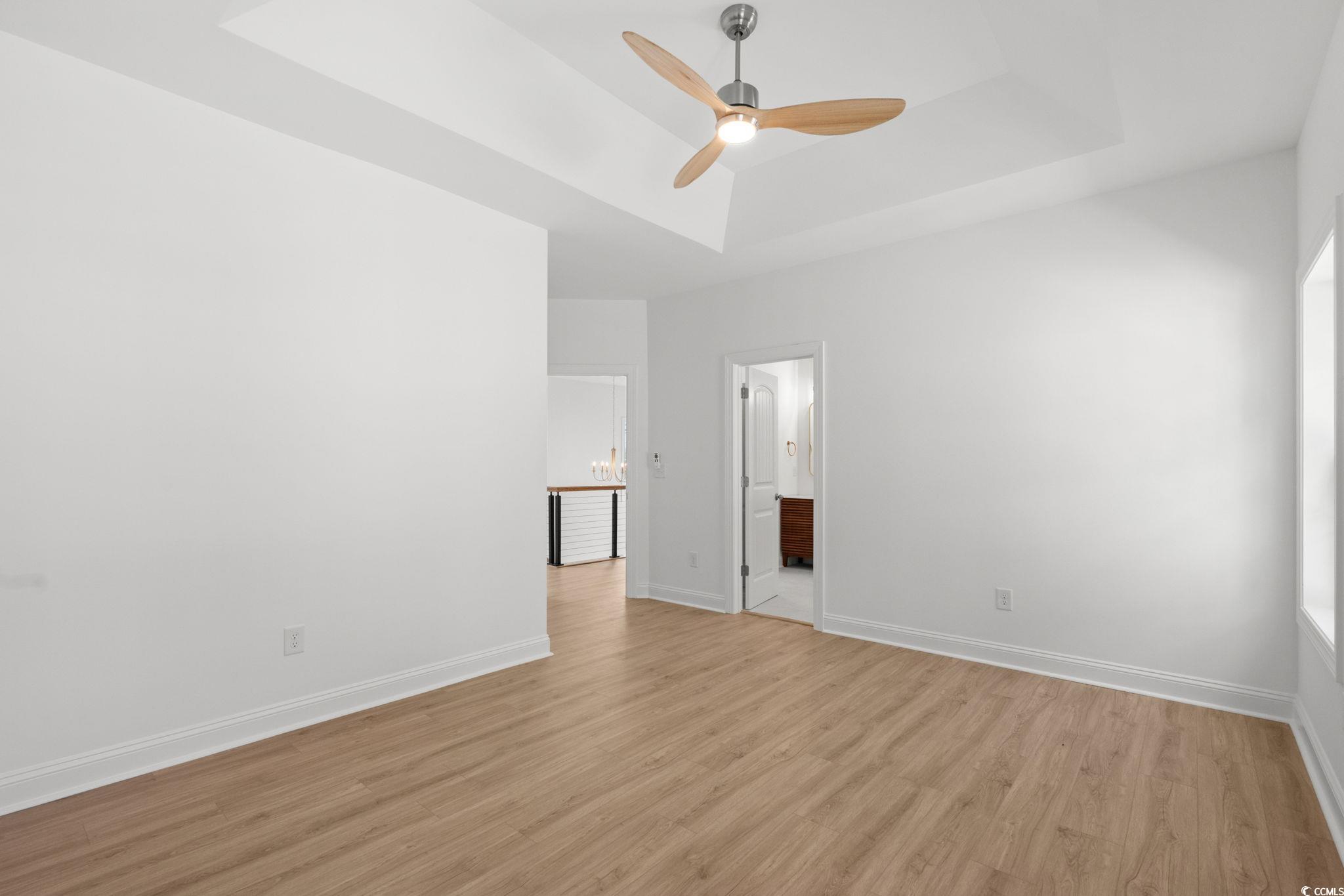 2247 Sand Dunes Drive Myrtle Beach, SC 29577 - Photo 27 of 40 Unfurnished bedroom featuring a tray ceiling, light wood-type flooring, ceiling fan, and connected bathroom