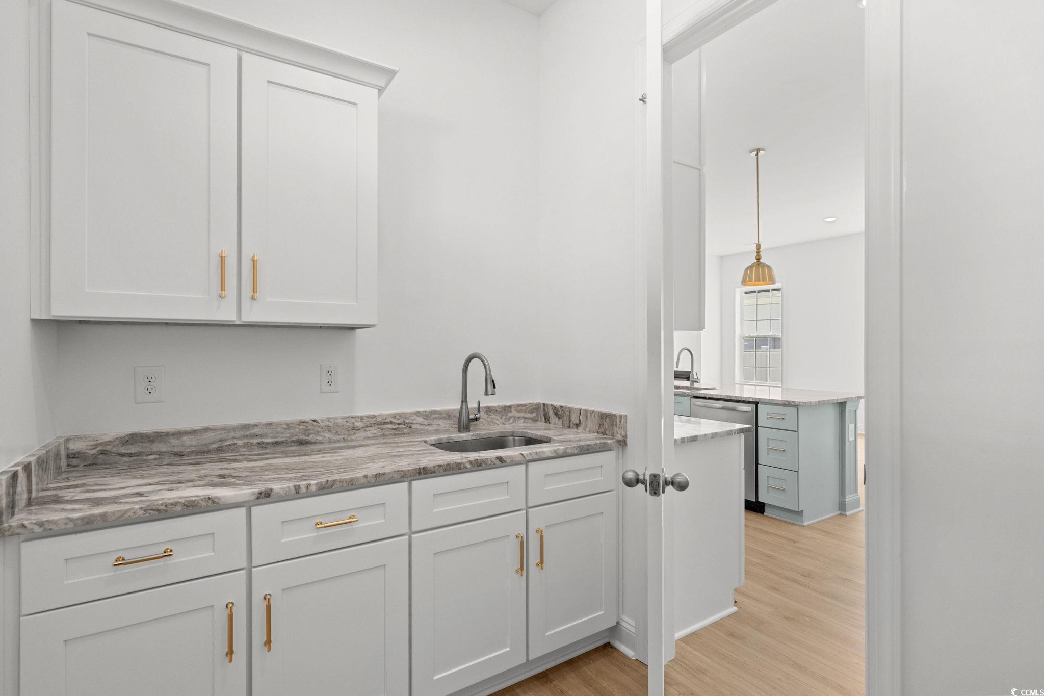 2247 Sand Dunes Drive Myrtle Beach, SC 29577 - Photo 29 of 40 Bar with light wood-type flooring, white cabinetry, hanging light fixtures, light stone countertops, and dishwasher