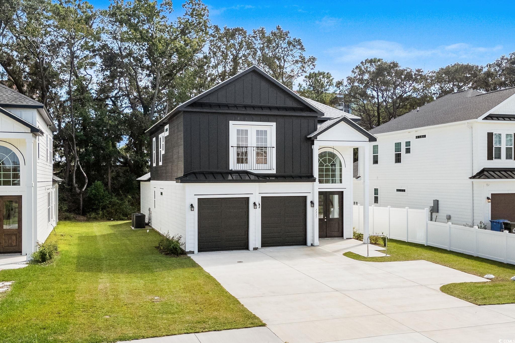 2247 Sand Dunes Drive Myrtle Beach, SC 29577 - Photo 33 of 40 Modern farmhouse featuring board and batten siding, an attached garage, concrete driveway, a metal roof, and a standing seam roof