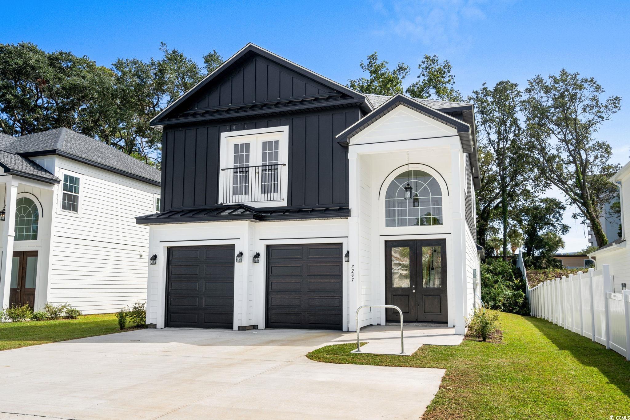2247 Sand Dunes Drive Myrtle Beach, SC 29577 - Photo 34 of 40 Modern farmhouse with board and batten siding, a garage, concrete driveway, a metal roof, and a standing seam roof