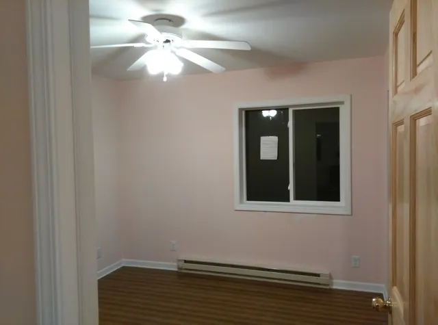 a view of a small space with wooden floor and a window