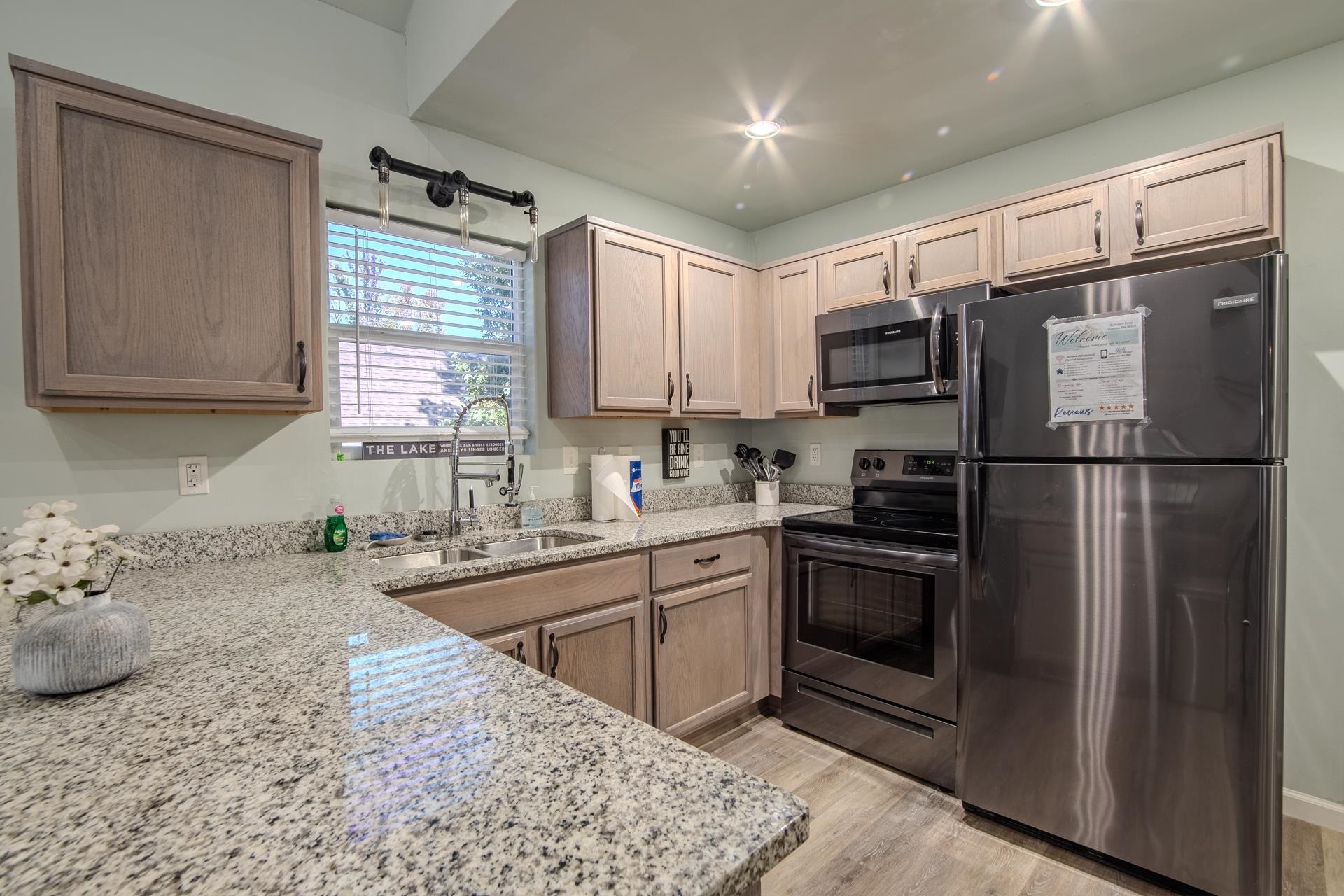 25 Bogey Loop Counce, TN 38326 - Photo 15 of 37 Kitchen with stainless steel appliances, light stone counters, light wood-style floors, and light brown cabinets