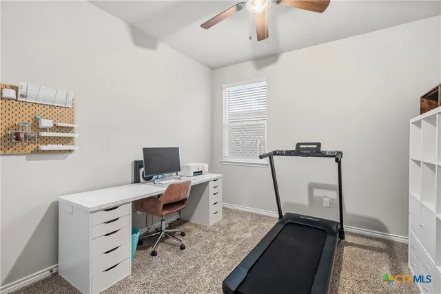 a view of a workspace with furniture and a window