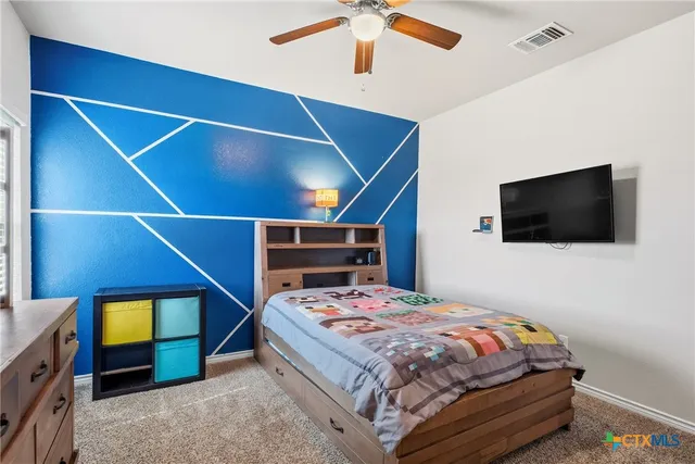 a bedroom with a bed and a television