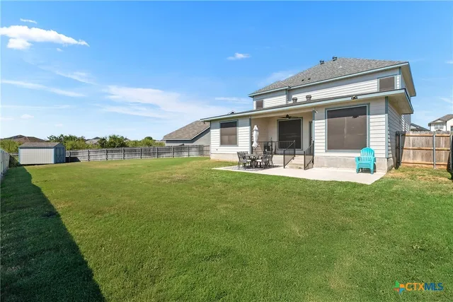 a view of a house with a big yard and a large tree