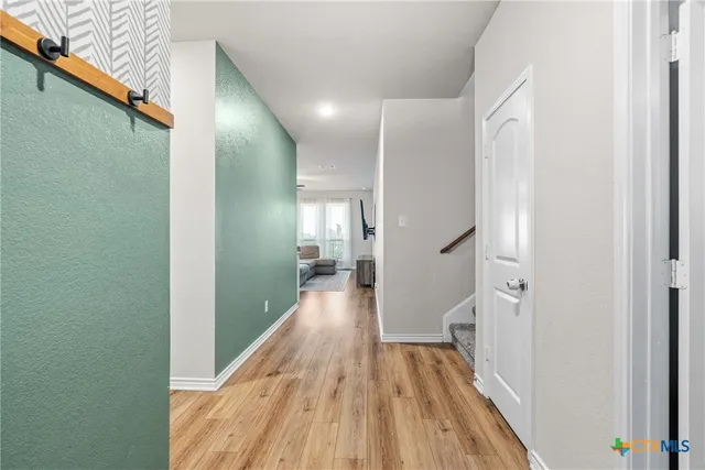 a view of a hallway with wooden floor and staircase