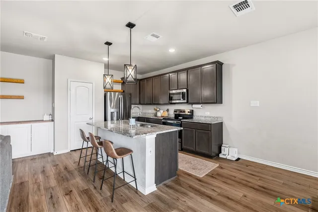 a kitchen with a sink a microwave a stove and refrigerator