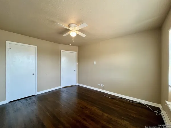 a view of an empty room with wooden floor