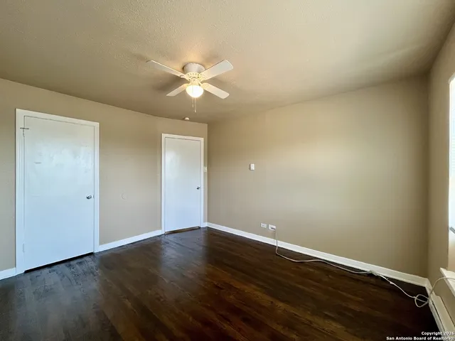 a view of an empty room with wooden floor