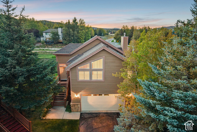 7396 Brook Hollow Loop Road Park City, UT 84098 - Photo 49 of 60 Multi-level exterior with horizontal siding, a prominent chimney, and an attached garage