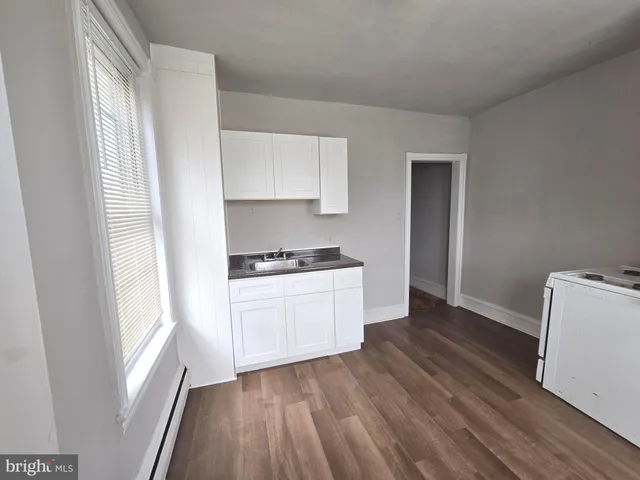 a kitchen with a refrigerator and white cabinets